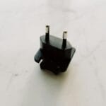 Czarny adapter podróżny leżący na białej marmurowej powierzchni