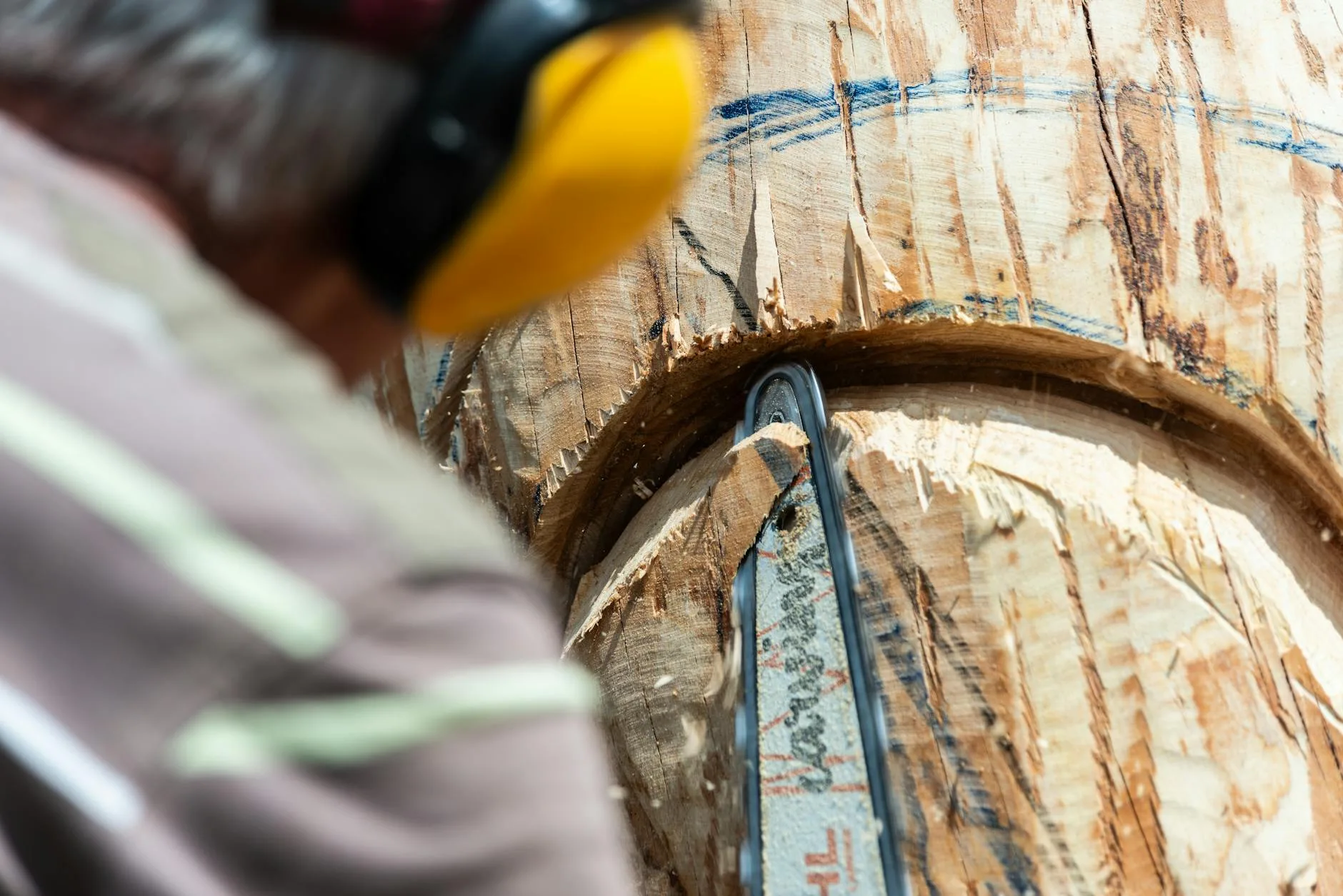 Artysta rzeźbi szczegółową drewnianą rzeźbę pilarką spalinową