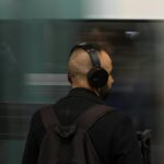 Mężczyzna w słuchawkach czeka na metro w ruchliwym miejskim tunelu
