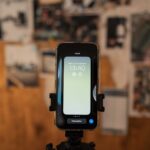 Zbliżenie smartfona z widoczną godziną na ekranie w rozmytym wnętrzu