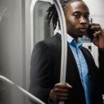 Biznesmen rozmawiający przez smartfon w wagonie metra