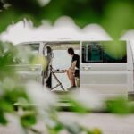 Osoba pracująca z laptopem w kampervanie z widokiem na naturę