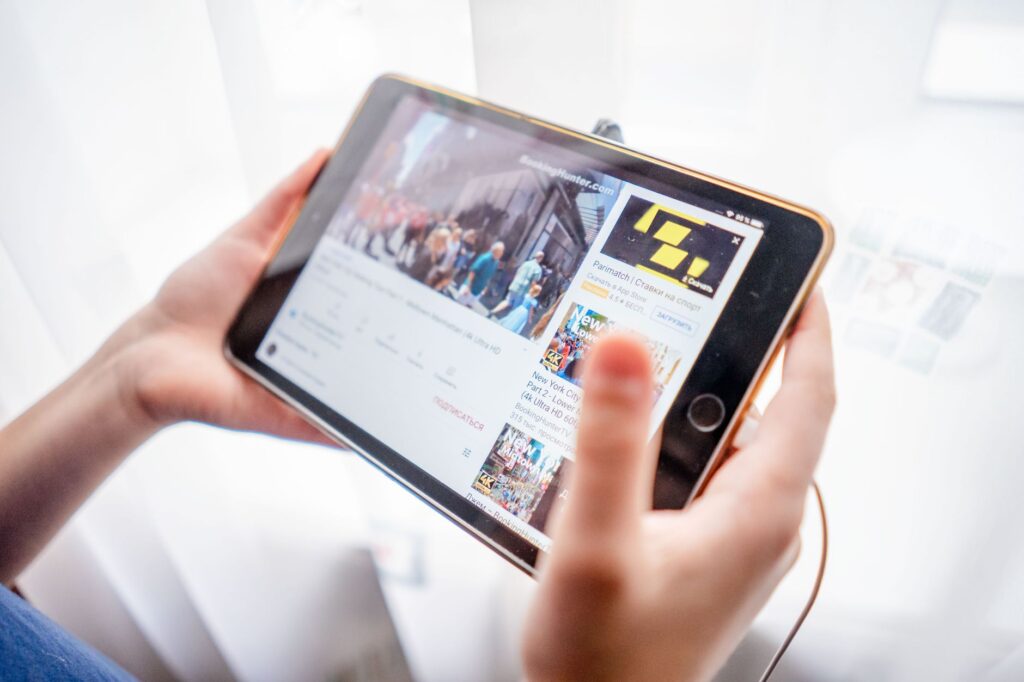 Zbliżenie na dłonie trzymające tablet podczas przeglądania treści online